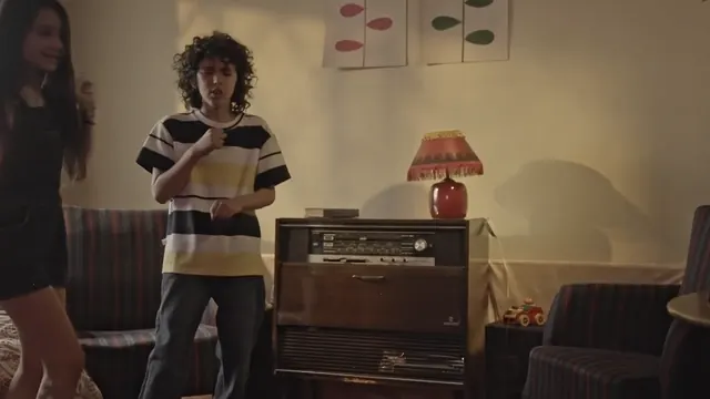 Young Franco dances in front of the TV while his sister watches