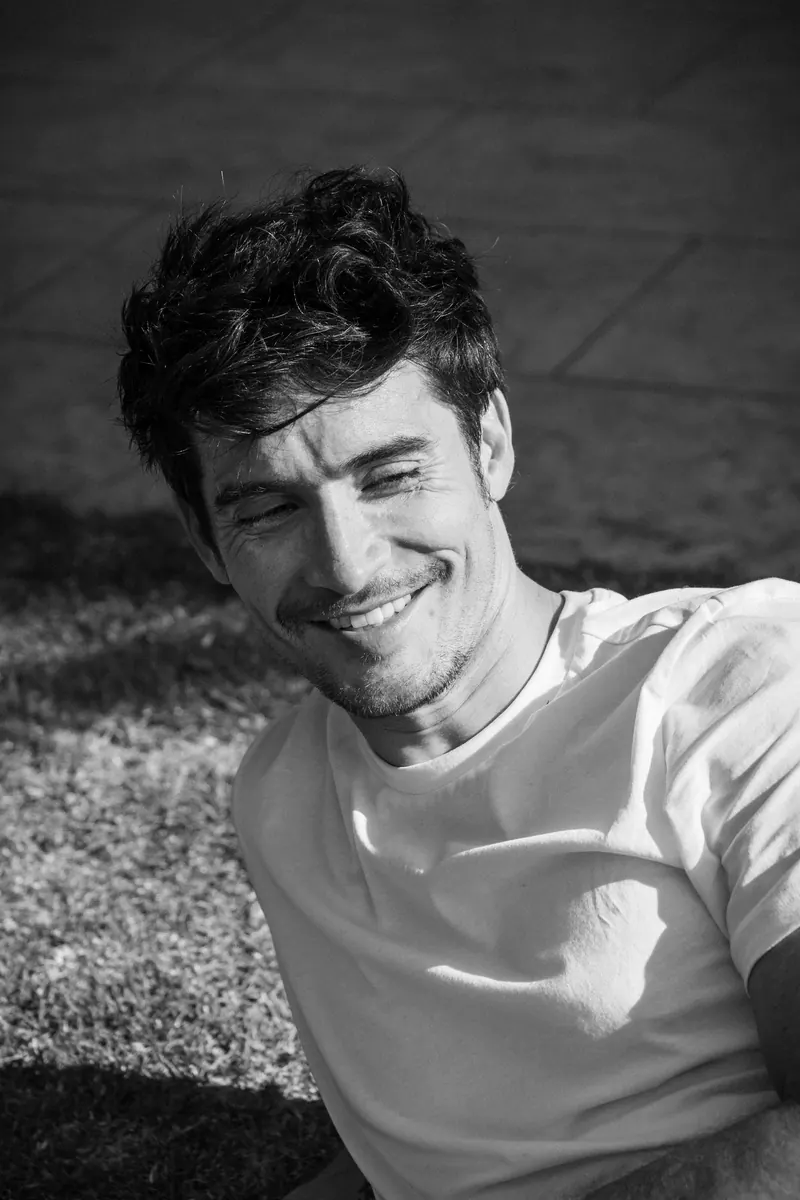 Black-and-white portrait of Rey Alcalde laughing